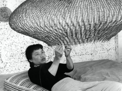 Portrait of Ruth Asawa forming a looped-wire sculpture 1957